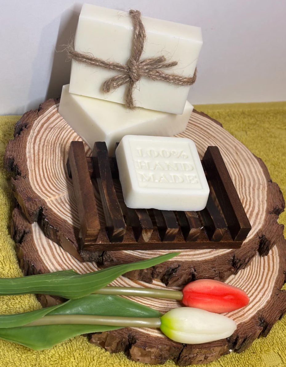 White unscented handmade soap bars tied with twine on a wooden soap dish