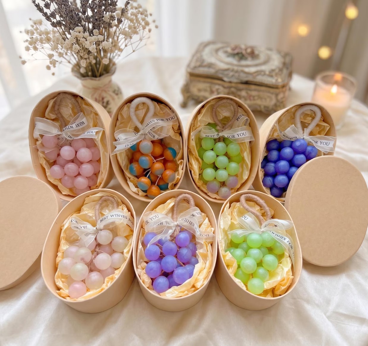 Oval kraft boxes with grape-bunch soaps in pink, green, purple and blue